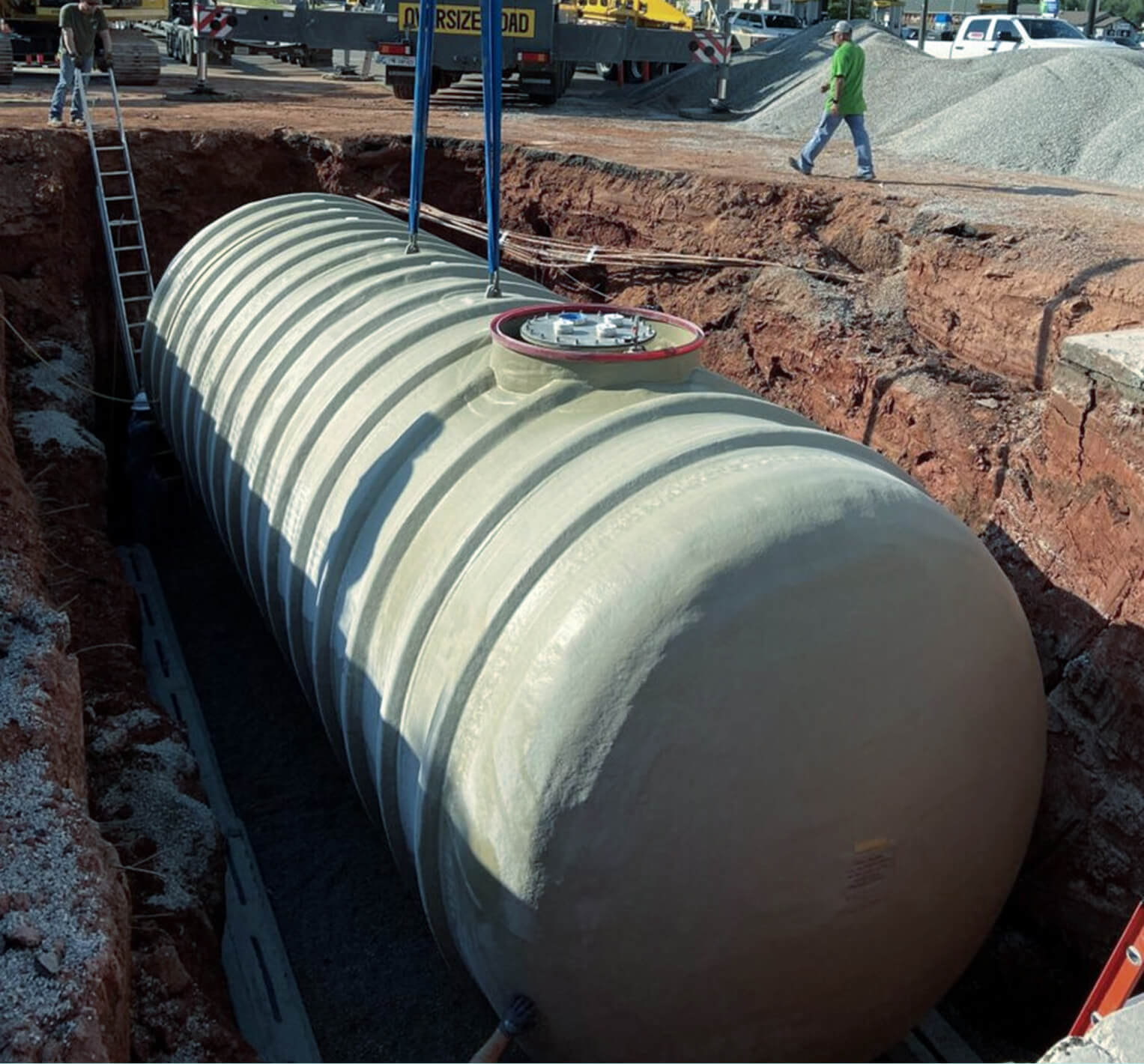 Partitioned fuel storage tank being installed in an excavation